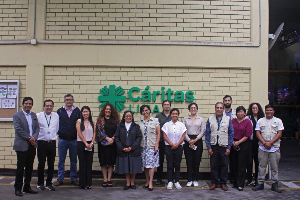 Fotografía grupal de representantes de la PUCP, Cáritas Lima y el Arzobispado de Lima.